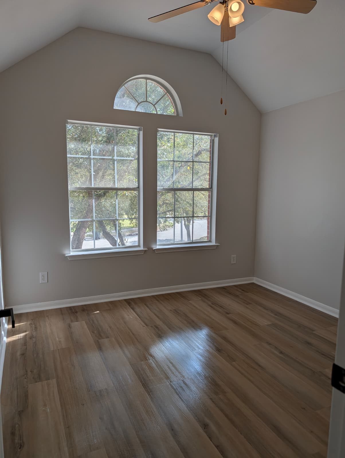 Bedroom with an arched window after new floors and paint