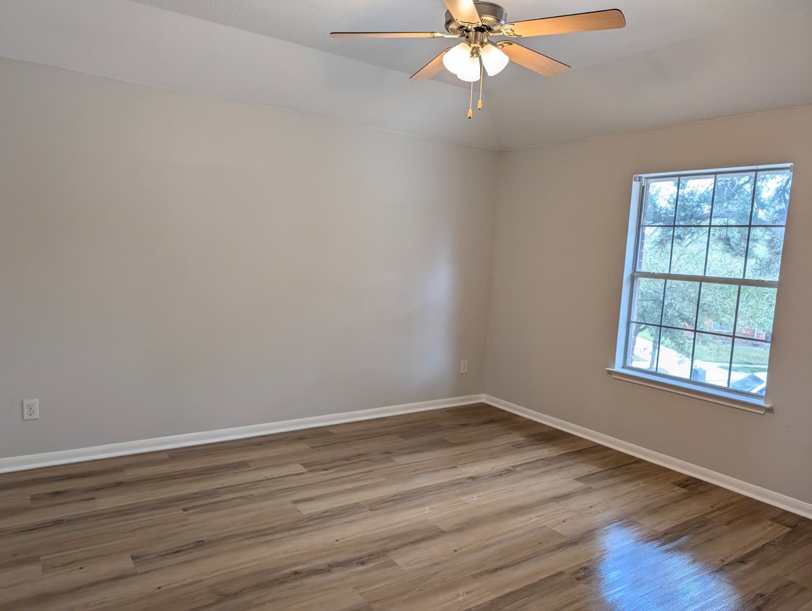 Finished bedroom with a window and ceiling fan