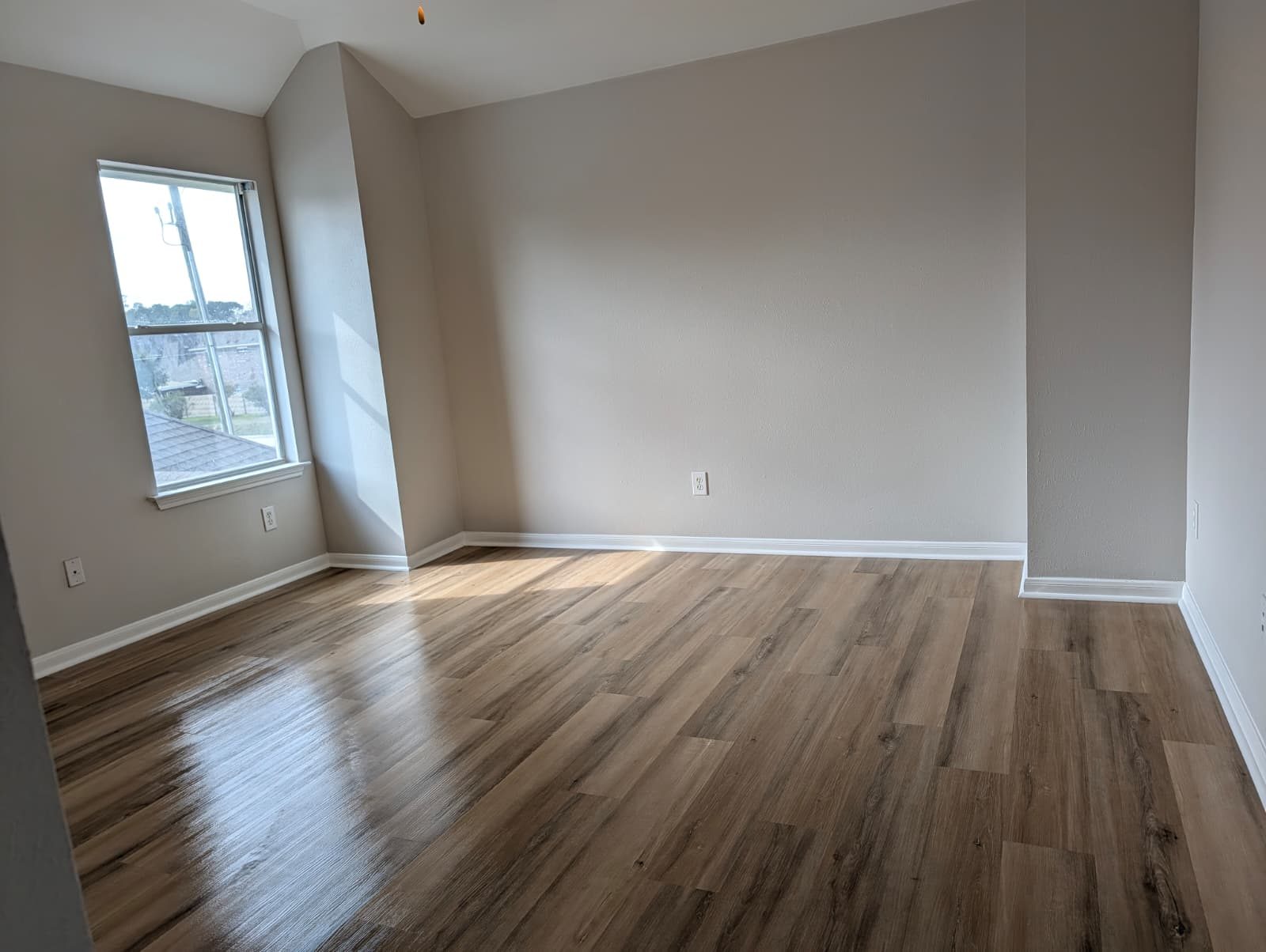 Bedroom after remodel with new floors and a window