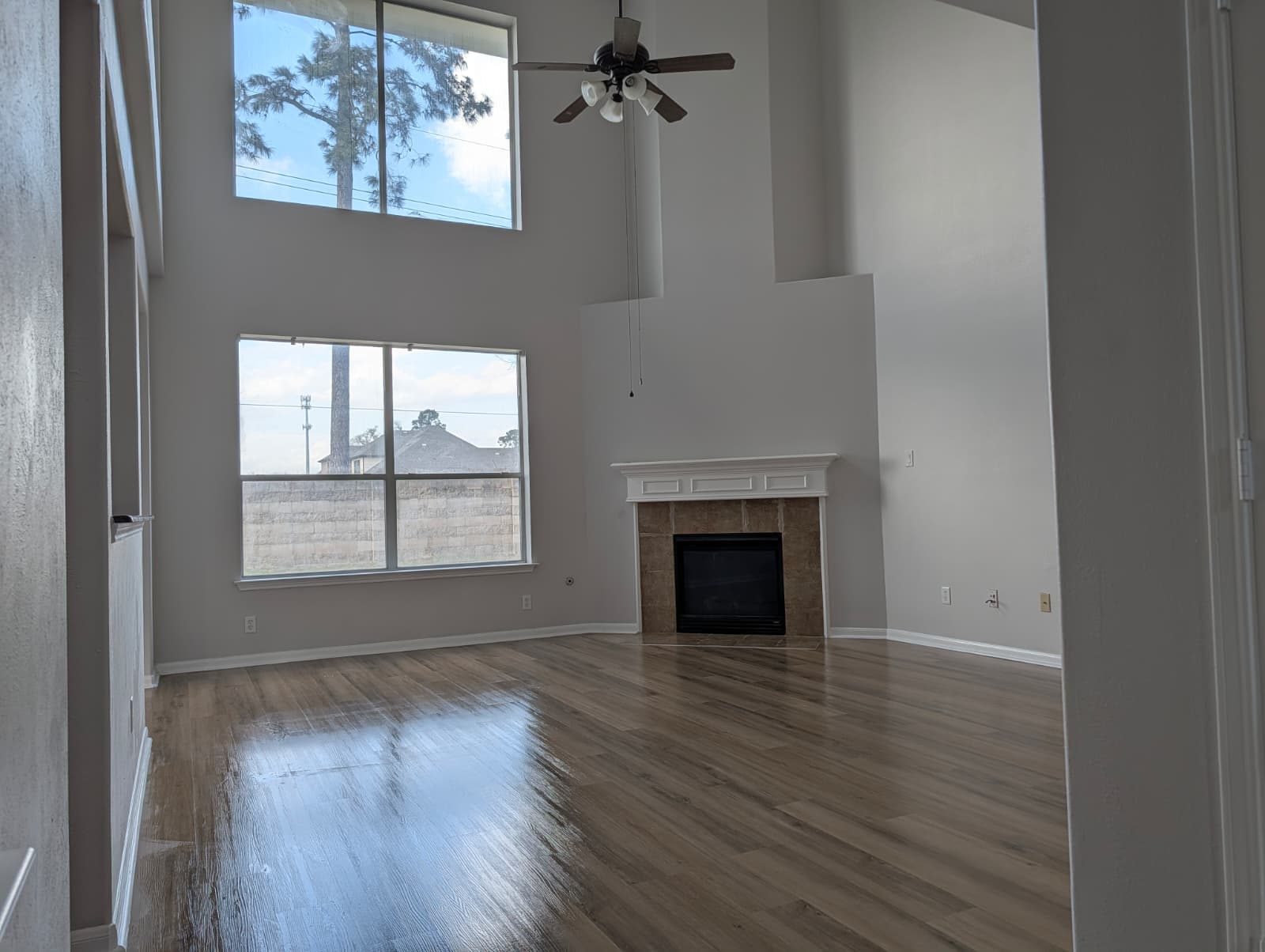 Living room after remodel showing tall windows and a new fireplace surround