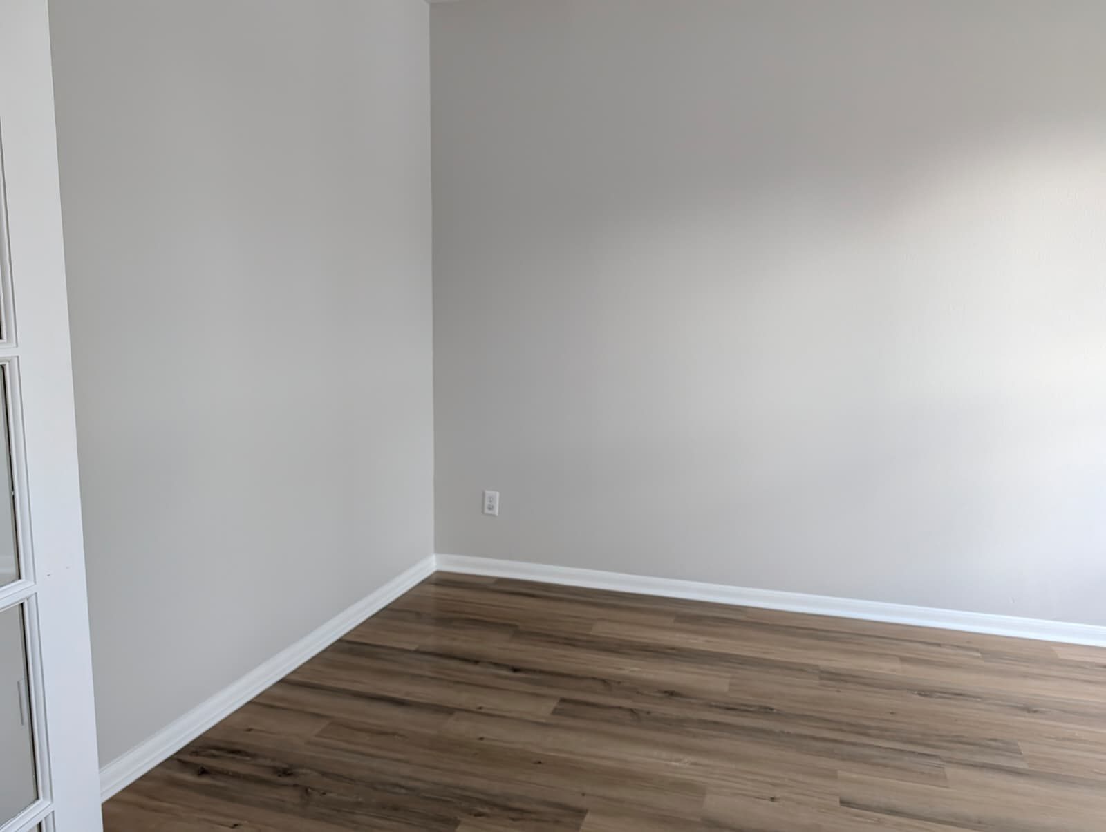 Corner of a finished room with new wood-look floors