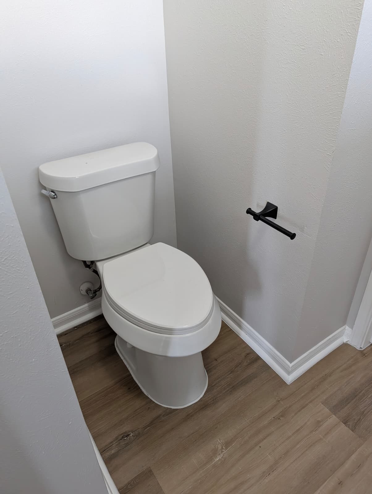 New toilet and black hardware in the remodeled bathroom