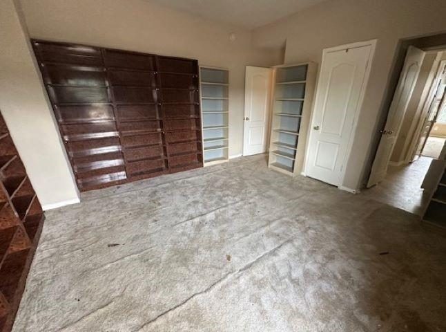 Dark built-in cabinets and worn carpet before the remodel
