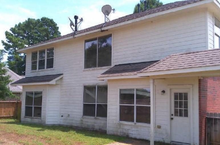 Faded white siding on the side of the house before the remodel