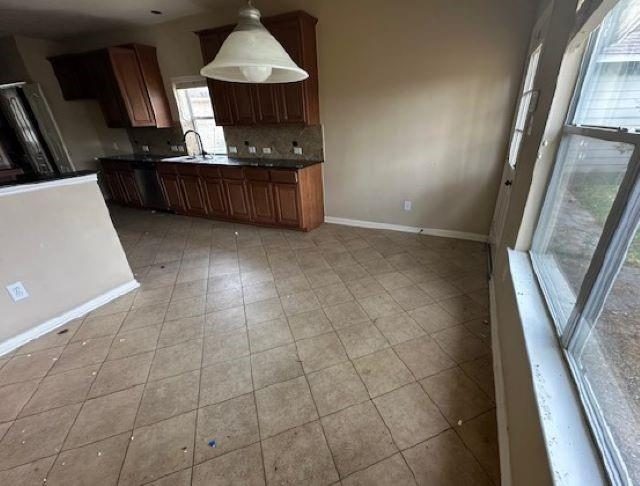Kitchen before remodel with tile floors and older cabinets