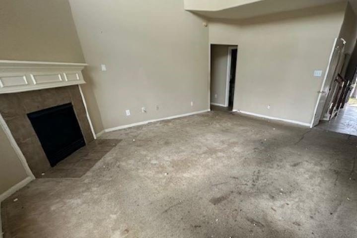 Living room before remodel with a bare floor and unfinished walls