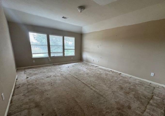 Empty bedroom with stained carpet before new flooring