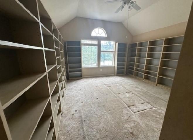 Room full of built-in shelves and stained carpet before the remodel